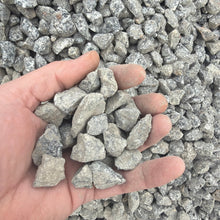 Load image into Gallery viewer, Hand holding small stones with a background of more stones