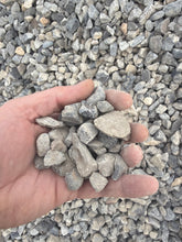Load image into Gallery viewer, Hand holding small stones against a background of similar stones
