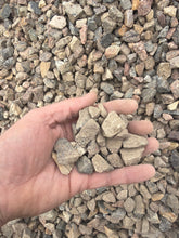 Load image into Gallery viewer, Hand holding small stones with a background of gravel
