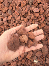 Load image into Gallery viewer, Hand holding red gravel with a background of more red gravel
